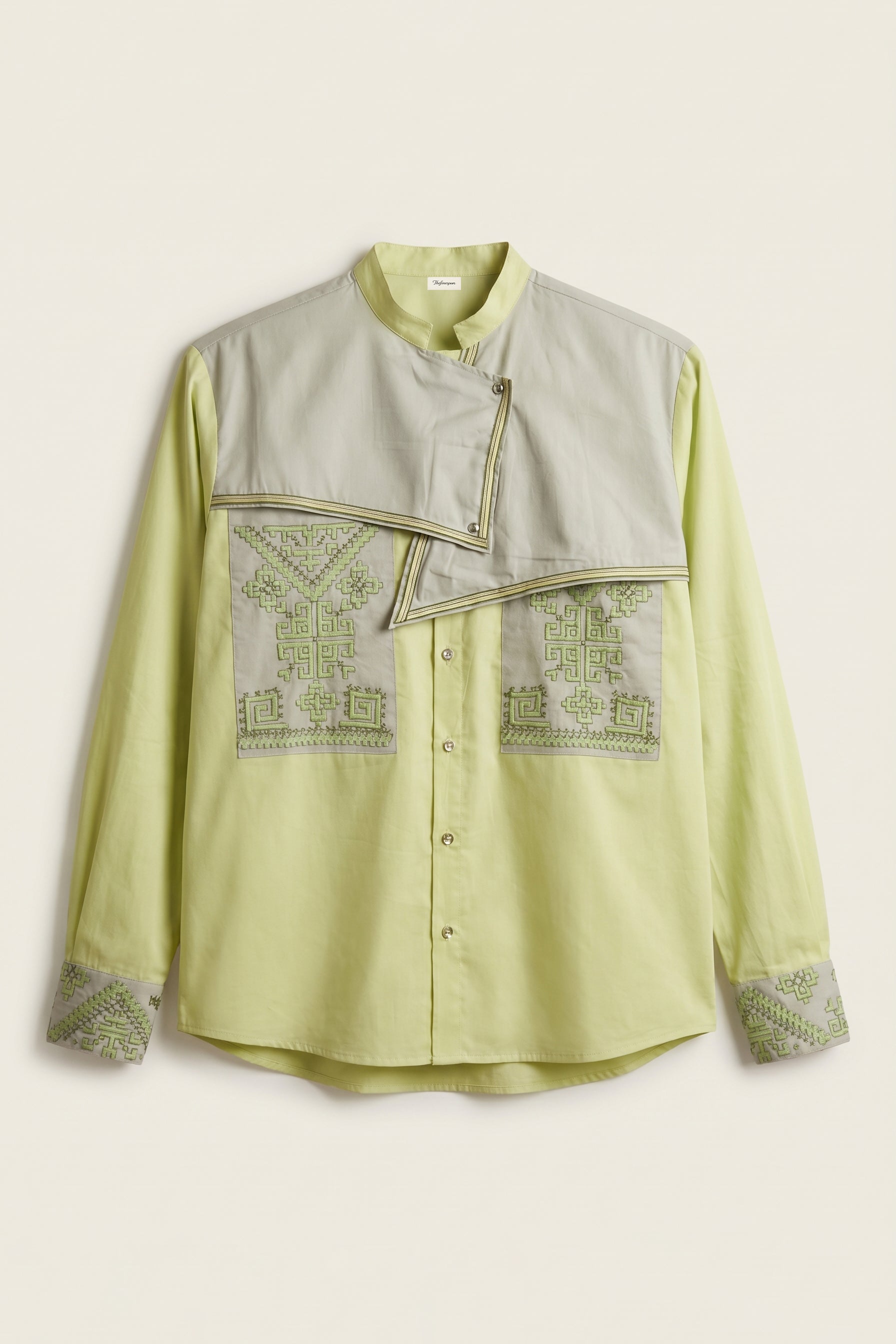Light green shirt with embroidered details on a beige background