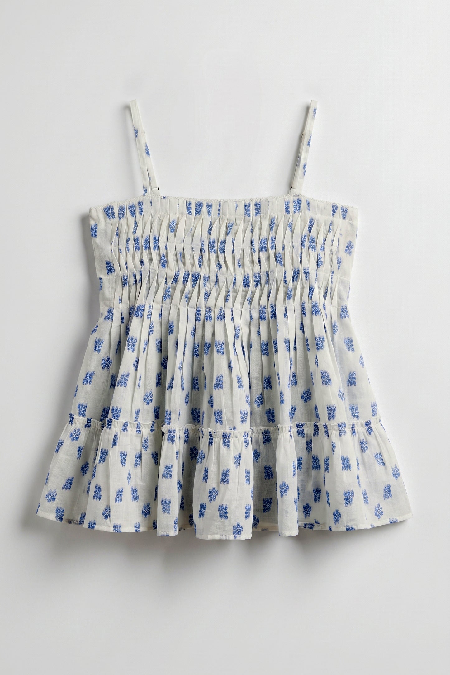 Vincent Pintuck Top for women in cotton dobby featuring handcrafted pintuck detailing, blue floral print, square neckline, and tiered peplum silhouette.