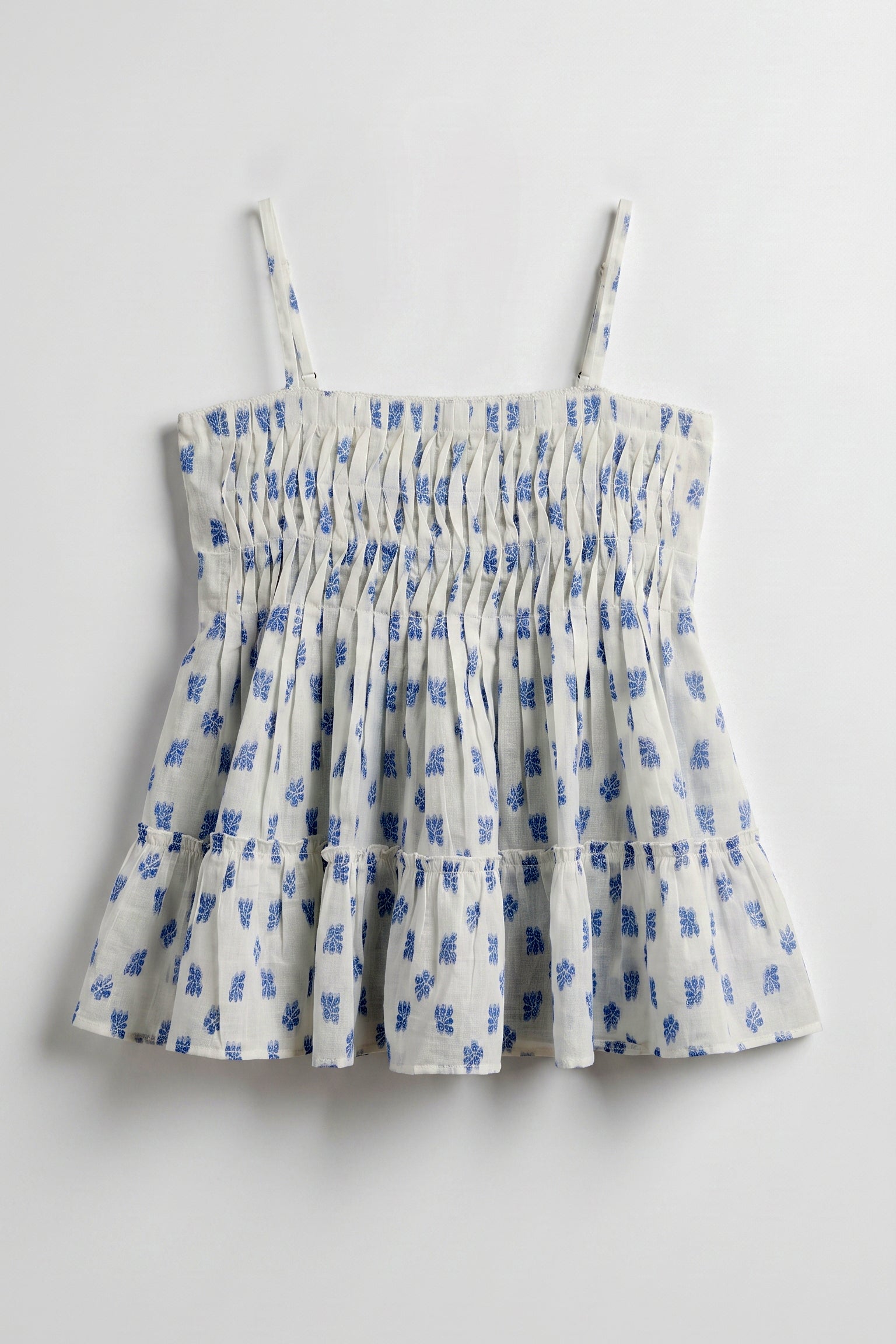 Vincent Pintuck Top for women in cotton dobby featuring handcrafted pintuck detailing, blue floral print, square neckline, and tiered peplum silhouette.