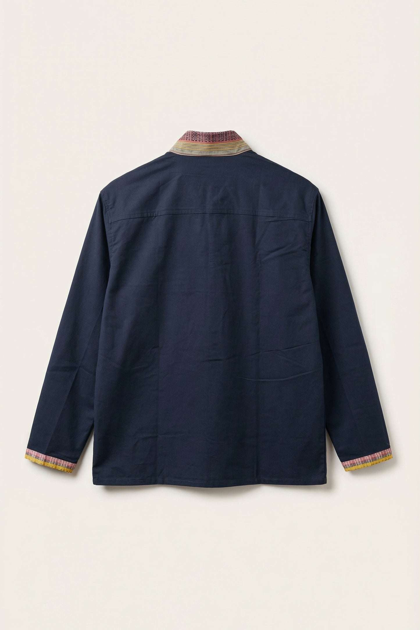 Navy jacket with patterned trim on a light beige background