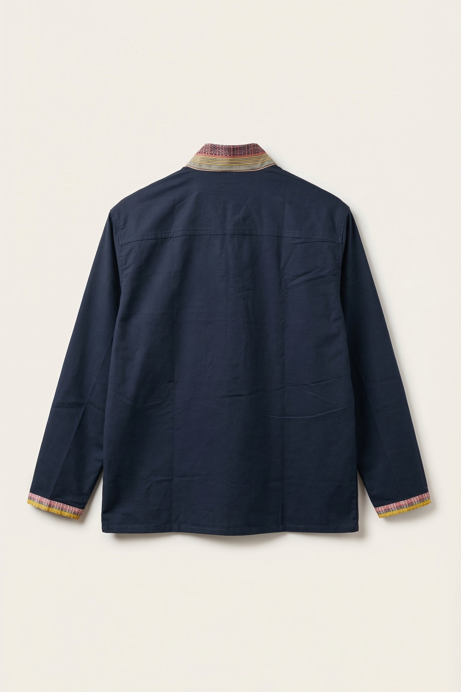 Navy jacket with patterned trim on a light beige background