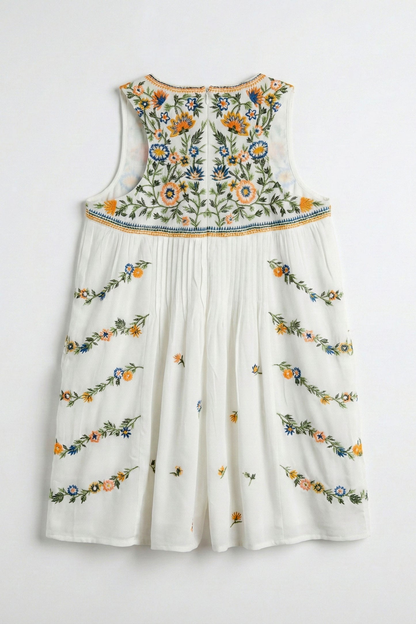 White dress with colorful floral embroidery on a white background