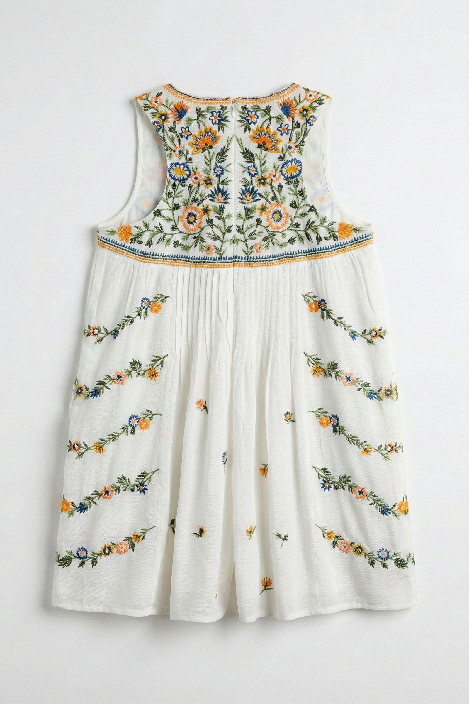 White dress with colorful floral embroidery on a white background