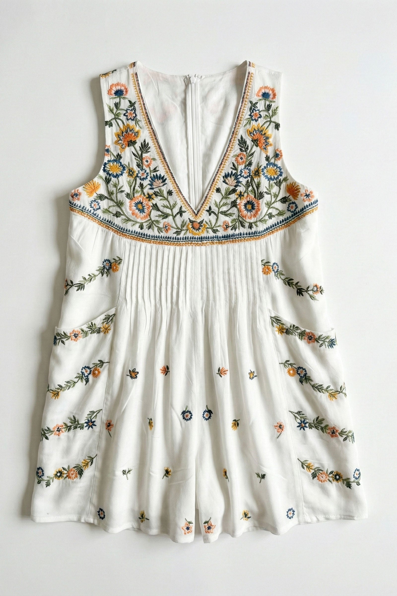 White romper with floral embroidery on a white background