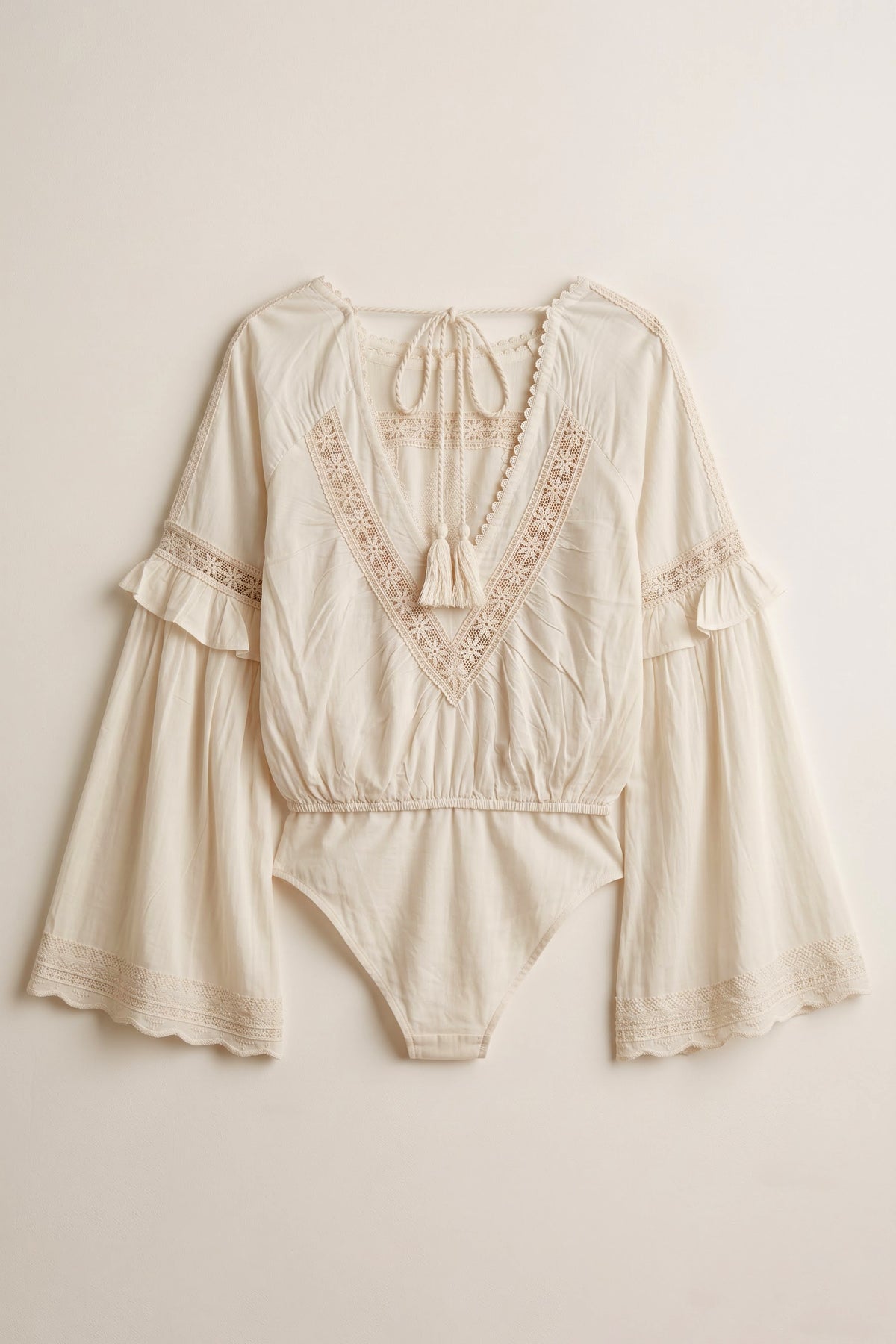Yasmin white rayon bodysuit featuring tonal daisy embroidery, lace detailing, flared sleeves and an open back with tassel ties