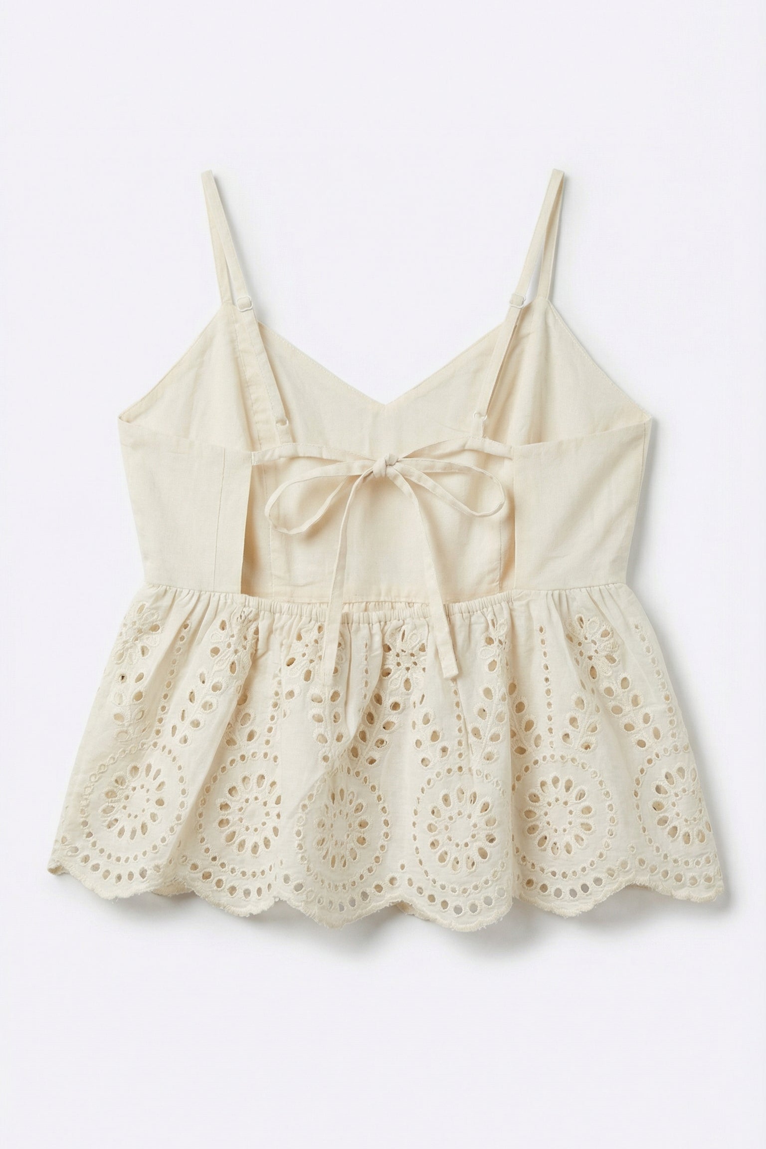 Beige lace top with thin straps on a light gray background