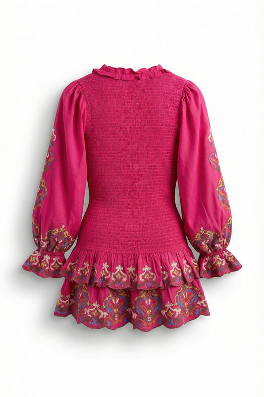 Pink dress with floral patterns on long sleeves and hem against a white background
