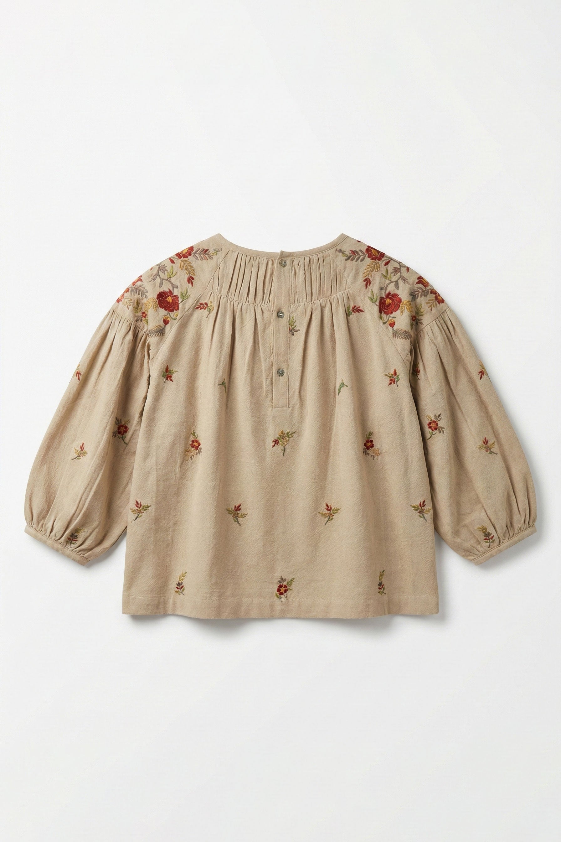 Beige blouse with floral embroidery on a white background