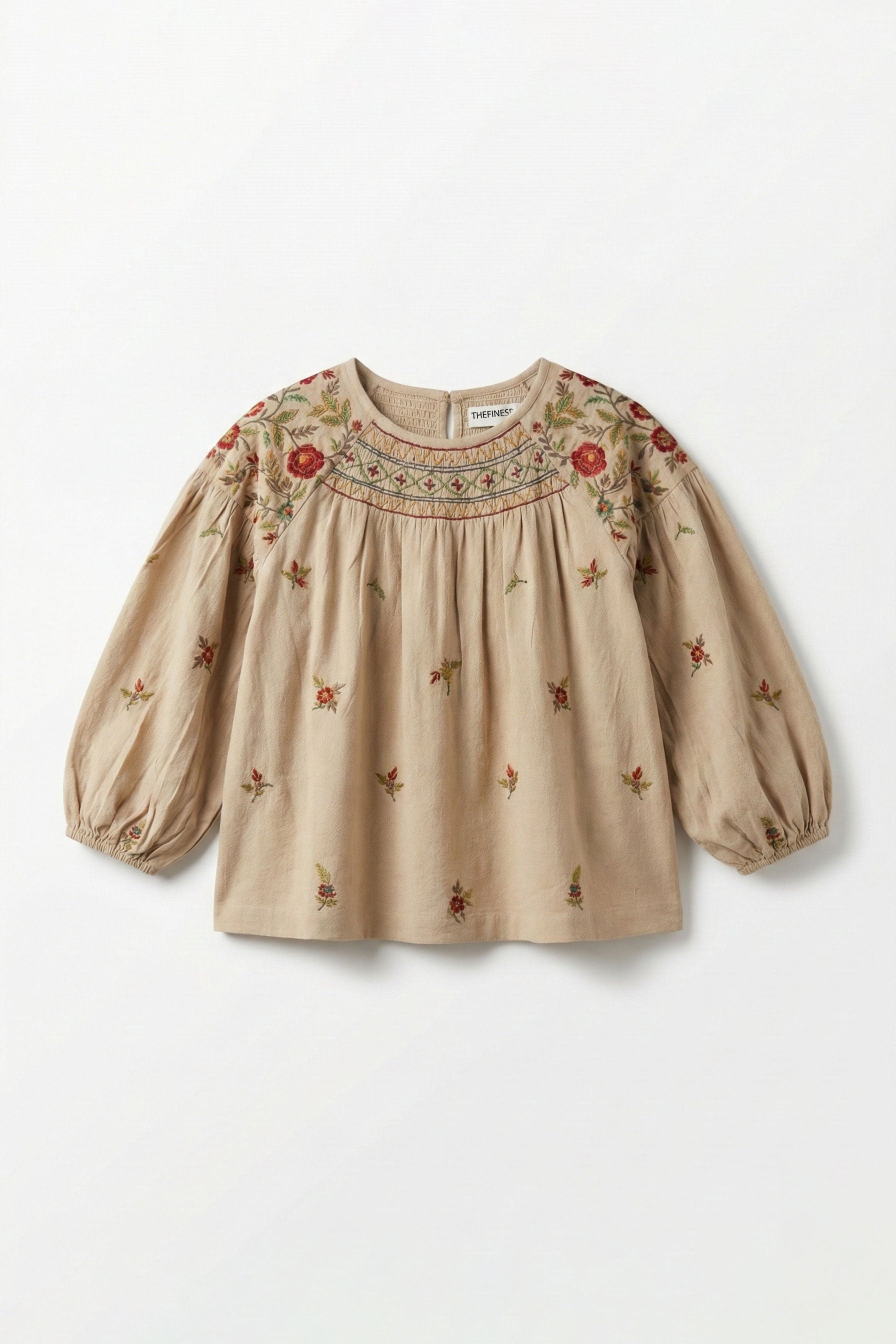 Beige blouse with floral embroidery on a white background