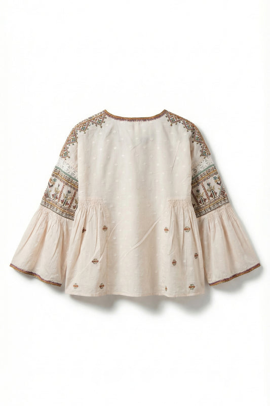 Beige blouse with intricate embroidery on a white background