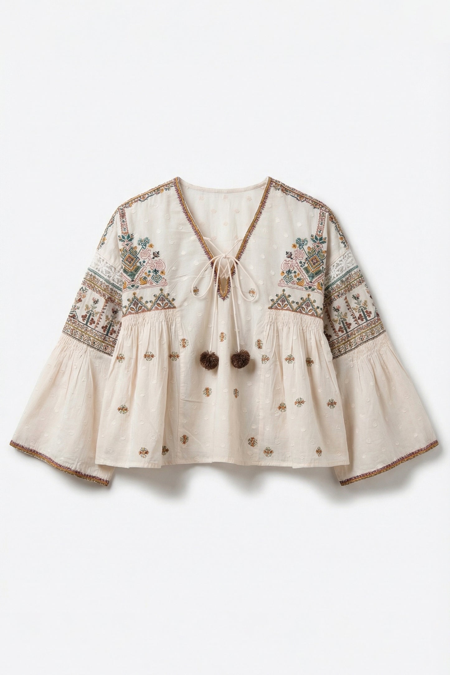 Beige blouse with intricate embroidery on a white background