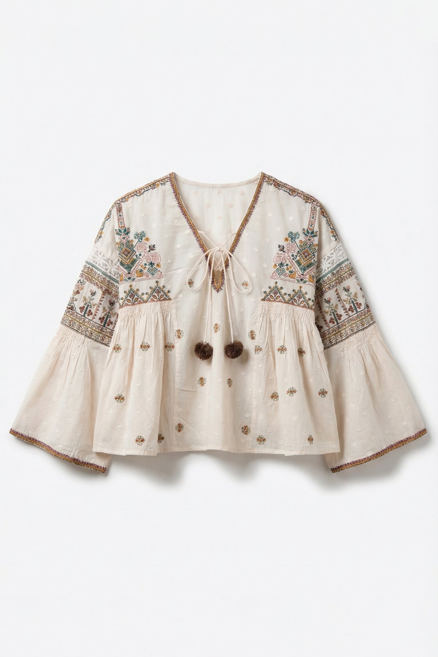 Beige blouse with intricate embroidery on a white background