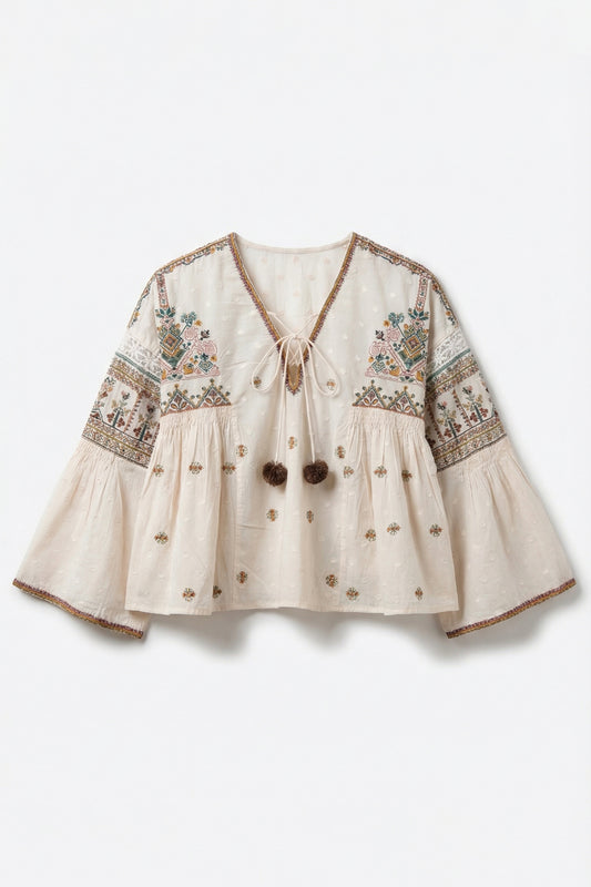 Beige blouse with intricate embroidery on a white background