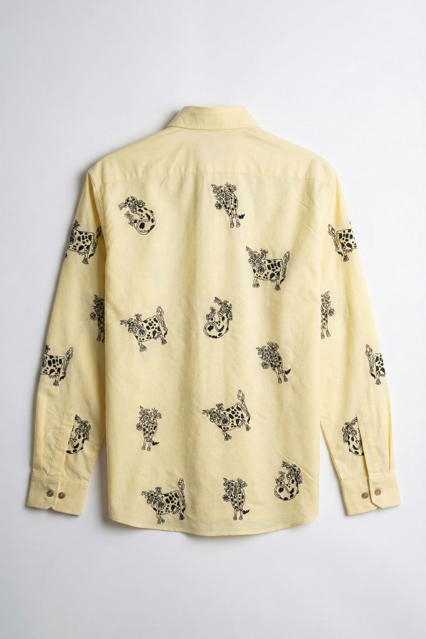 Yellow shirt with black pattern on a light gray background